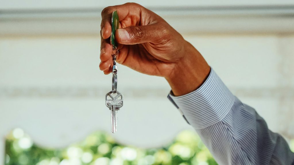A man's hand offers up a new key - Visit afinestpm.com. 
