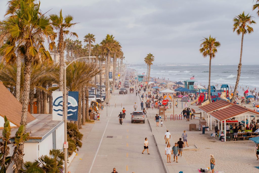 A beach in San Diego with people walking up and down the street - visit afinestpm.com. 